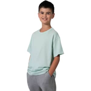 A kid's regular t-shirt in mint green, worn by a smiling boy with his hands in grey pants pockets.