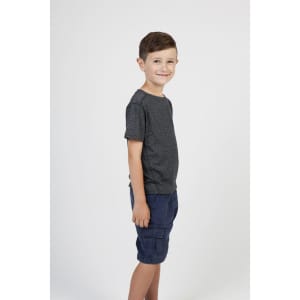 A grey heather t-shirt is worn by a young boy standing sideways, paired with navy shorts. The shirt has a logo.