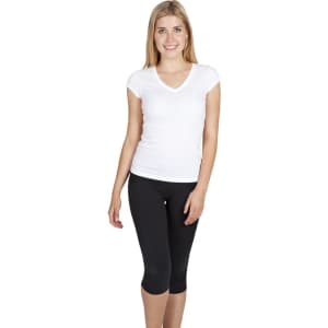 A woman wearing a white V-neck T-shirt paired with black leggings, smiling at the camera. The T-shirt has a logo.