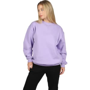 A woman wearing a light purple poly cotton fleece jumper with a relaxed fit. The jumper features a logo.