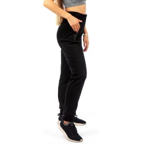 Brushed fleece track pants in black, featuring a high waist and a zip detail, styled with a grey crop top and black sneakers.