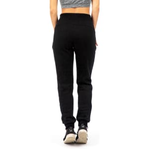 Brushed fleece track pants in black, featuring a snug fit and elastic waistband, modelled from the back.
