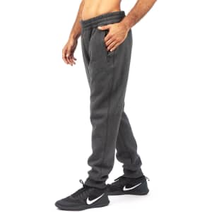 Brushed fleece track pants in dark grey, featuring side pockets and elasticised waistband, worn with black sneakers.