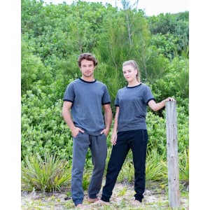 Men's STANCE brushed fleece pants in grey and black, styled with matching tees, set against a natural green background.