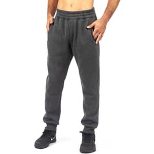 Brushed fleece track pants in dark grey with an elastic waistband and side pockets, featuring a logo.