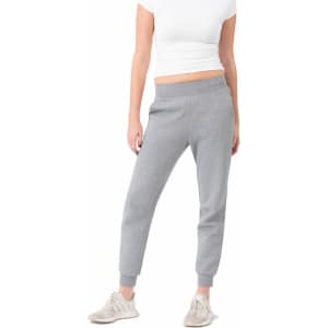 Grey women's track pants with a tapered fit and elasticated waistband, paired with light-coloured footwear.