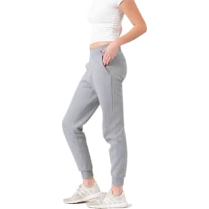 Grey three-layer cotton track pants with side pockets, featuring a fitted design and cuffed ankles.