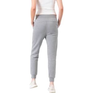 A pair of grey women's track pants with a fitted ankle design and a soft cotton fabric. The pants feature a logo.