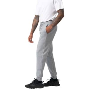 Men's three-layer cotton sandwich pants in grey, featuring side pockets and a drawstring waist. Styled with black trainers.