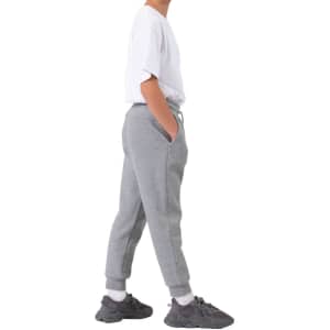 A pair of grey three-layer cotton track pants with side pockets, modelled by a person wearing a white t-shirt and sneakers.