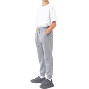 Three-layer cotton track pants in grey, featuring a relaxed fit and side pockets, paired with a white t-shirt and sporty shoes.