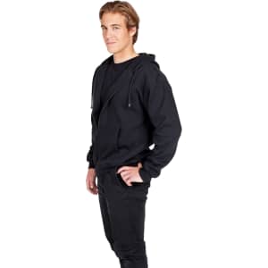A black zip hoodie with a pocket, worn by a man standing sideways, showcasing the garment's relaxed fit.
