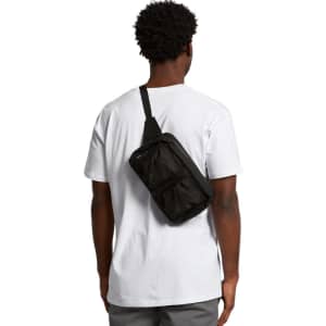 A man wearing a white t-shirt displays a black recycled double waist bag on his back, featuring a logo.