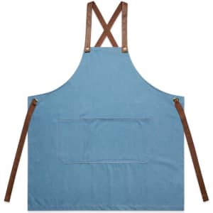 A denim apron in blue with brown leather straps and a large front pocket, featuring a logo.