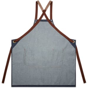 A denim apron in blue with brown straps, featuring a pocket at the front and a logo.