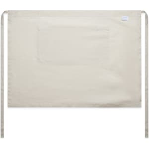 A beige linen half apron featuring a front pocket and ties for fastening, with a logo on the side.