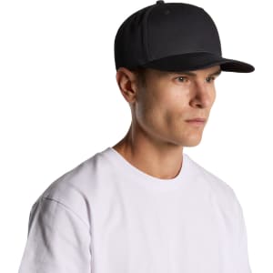 A dark grey cap is worn by a model with short hair, paired with a plain white t-shirt. The cap has a logo.