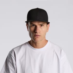 A black flex cap worn by a model, featuring a structured front and a plain design.