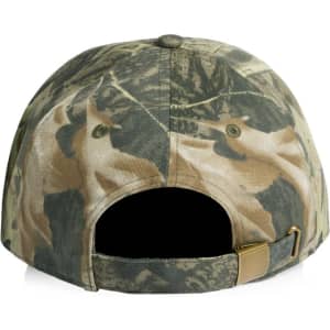 A camo cap featuring a blend of greens and browns, with a brass fastening at the back and a logo.