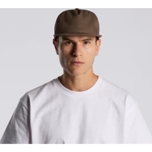 A brown cap with a structured design, featuring a logo, worn by a model in a white t-shirt.