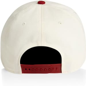 A two-tone cap in cream and burgundy with a rear adjuster and a logo.