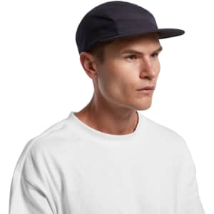 A cap in navy blue with a mesh design, featuring a branded logo, worn by a model with a neutral expression.