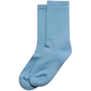 Two pairs of light blue socks arranged neatly, made from soft fabric, with a simple design.