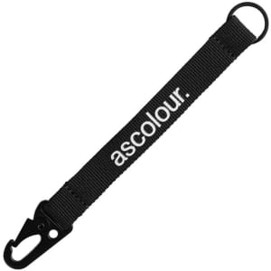 A black keychain made of fabric with a clip and a ring for holding keys, featuring branding.