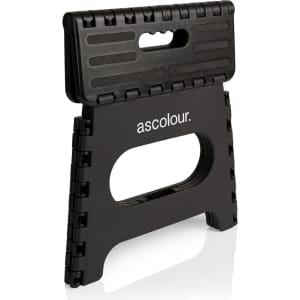 A black folding utility stool with a handle and a textured surface, featuring a logo on the front.