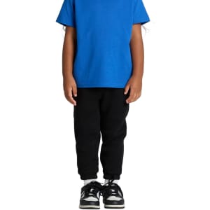Track pants in black worn by a child, paired with a blue shirt and black shoes. The pants have elastic cuffs and a logo.