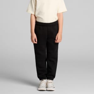 Youth Relax Track Pants in black, featuring an elastic waistband and a relaxed fit, paired with a plain t-shirt and sneakers.