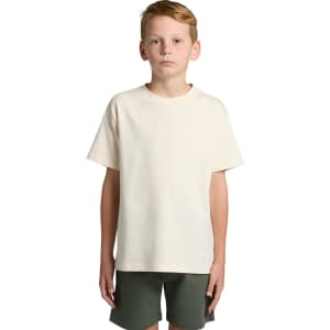 A plain cream youth classic tee with short sleeves, paired with dark green shorts. Features a logo on the tee.