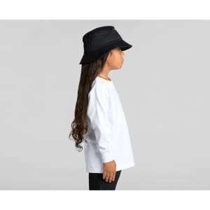 A child in a white long-sleeve tee and a black bucket hat, standing in profile against a neutral background.