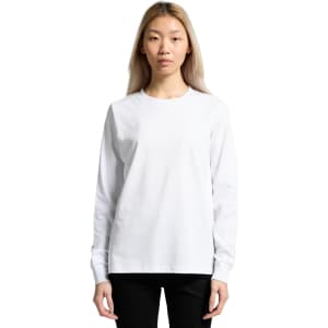 A long-sleeve white t-shirt featuring a simple design and a logo. The model is wearing black pants.