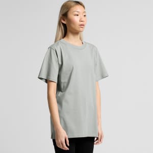 A model wearing a grey T-shirt with short sleeves and a relaxed fit, featuring a simple design.