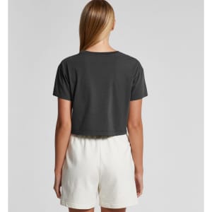 A faded grey crop tee worn with white shorts, displayed from the back. The shirt features a branding logo.