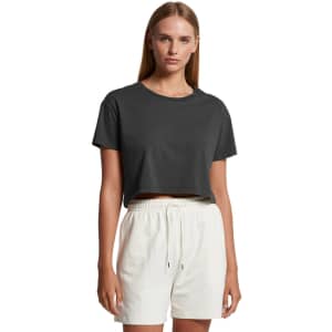 A cropped t-shirt in dark grey, paired with light-coloured shorts, featuring a simple design and a logo.