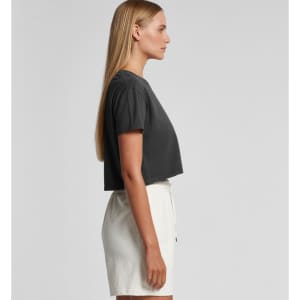 A cropped grey t-shirt with short sleeves, displayed on a model wearing white shorts, featuring a logo.