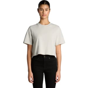 A cropped, heavy faded t-shirt in light grey, displayed on a model with black jeans. The shirt has a logo.