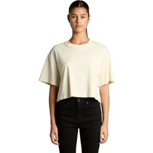 A cropped tee in a soft yellow colour, featuring short sleeves and a relaxed fit. Includes branding on the shirt.