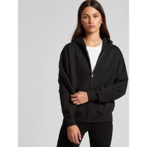 A black zip-up hoodie with a hood, featuring a front zip and long sleeves. The model poses casually.