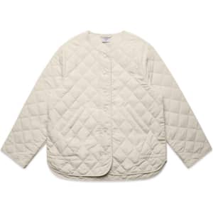 A cream-coloured quilted jacket with a rounded hem and snap buttons, featuring a logo on the label.