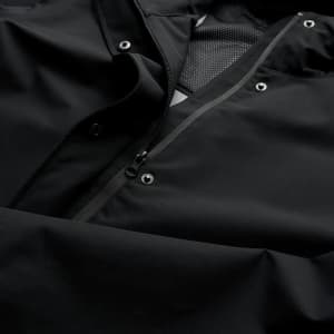 A soft shell jacket in black, featuring a zip and snap closures, with a textured interior lining.