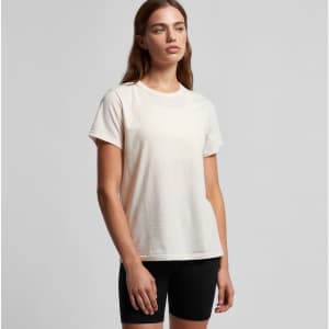 A light cream T-shirt with a relaxed fit, paired with black shorts. The shirt features a logo on it.