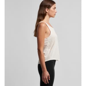 A light beige racerback singlet with a loose fit, featuring a logo on the side. Wellington leggings are worn with it.