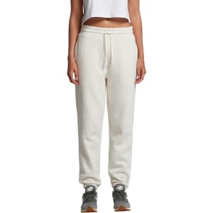 Cream track pants with an elastic waistband displayed on a model, featuring a logo.