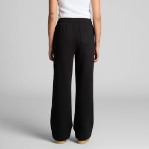 Cuffless black track pants with a relaxed fit and a back pocket, showcased on a model from the rear.