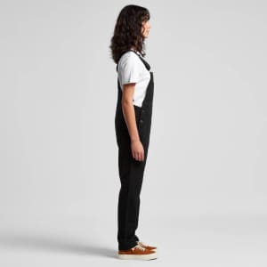 Black canvas overalls worn with a white T-shirt and brown shoes, displayed in a side view. The outfit features a logo.