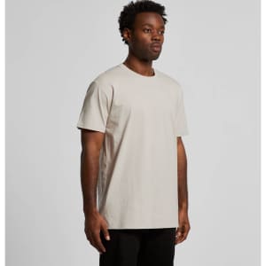 A plain beige T-shirt displayed on a model, featuring a round neckline and short sleeves. It has a brand logo.