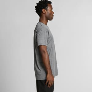 A side view of a grey T-shirt worn by a person, featuring a simple design and a visible logo.